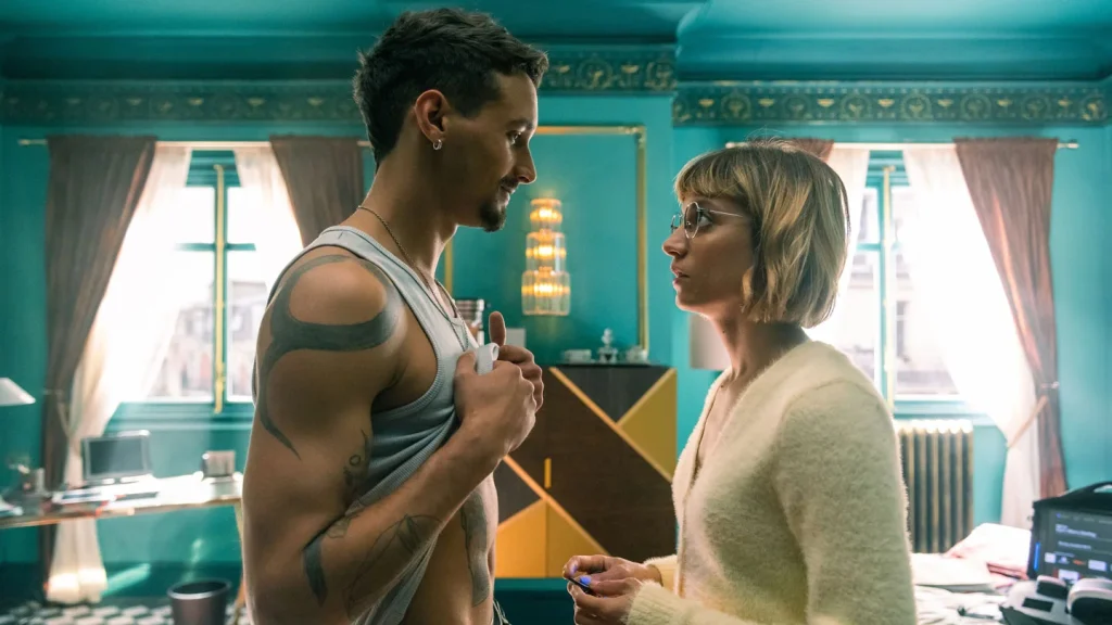 Crítica de Berlín, el spin-off de La casa de papel. En la imagen, Bruce y Keila, miembros del equipo, se miran a los ojos. Bruce tiene la camiseta de tirantes blanca levantada, enseñando los abdominales.